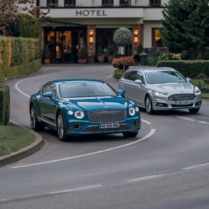 Bentley vor Hoteleinfahrt wird von Ford Mondeo überholt